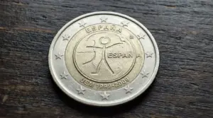 Moneta da 2 euro Spagna 2009 con figura stilizzata e stelle grandi sul bordo