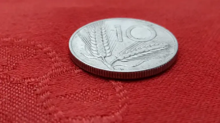 Moneta da 10 lire italiana del 1960 posata su tessuto rosso