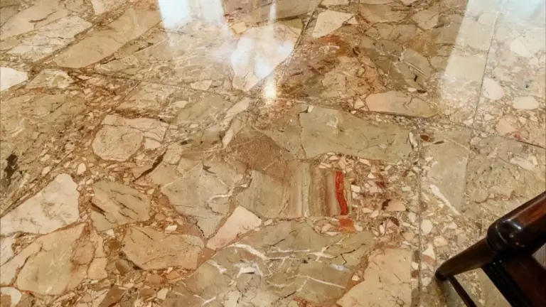 Primo piano di un pavimento in marmo lucidato con venature beige e rosse