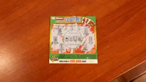 Un gratta e vinci parzialmente grattato su un tavolo di legno.