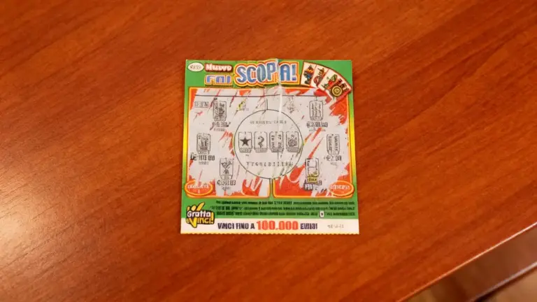 Un gratta e vinci parzialmente grattato su un tavolo di legno.
