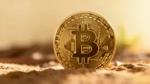 Moneta fisica con simbolo Bitcoin su sfondo sfocato