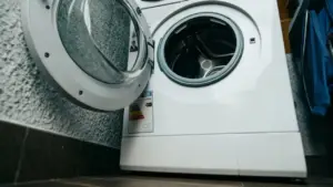 Oblò aperto di una lavatrice vista dal basso in una lavanderia