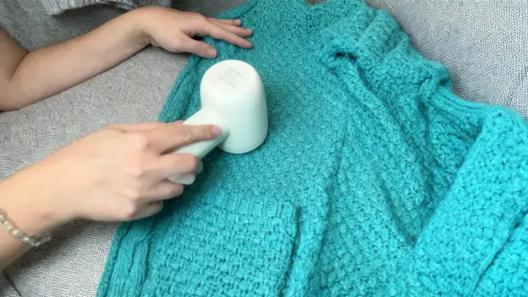 Una persona utilizza un rasoio elettrico per rimuovere pelucchi da un cappotto di lana turchese