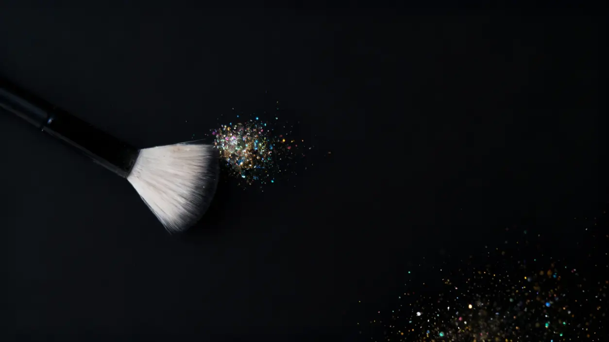 Pennello che solleva polvere brillante su sfondo nero