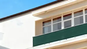Pannello frangivista verde installato su un balcone di un edificio moderno