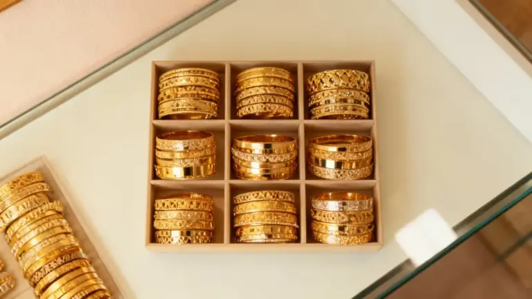 Bracciali d'oro disposti in una scatola espositiva su un banco di gioielleria